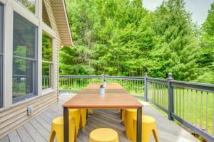 a deck with a wooden table and yellow chairs at Paddle & Pine in Bleecker +39 photos