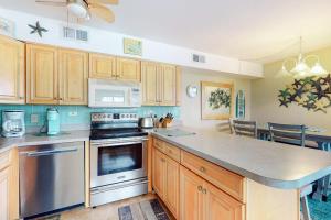 a kitchen with wooden cabinets and a stove top oven at Surfs Up 301 in Ocean City +16 photos