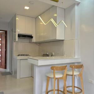a kitchen with two bar stools and a sink at La Casa 1101 in Amoloñgin