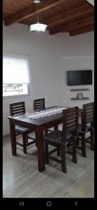 a dining room table with chairs and a television at Departamentos Muy Eugenia in San Rafael
