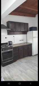 a kitchen with a stove and a refrigerator at Departamentos Muy Eugenia in San Rafael