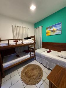 a room with two bunk beds and a rug at Beach House Suítes Jeri in Jericoacoara