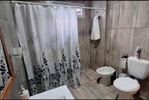 a bathroom with a shower curtain and a toilet at Departamentos Muy Eugenia in San Rafael +9 photos