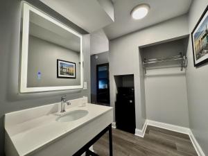 a bathroom with a sink and a mirror at O'Hare Inn & Suites in Schiller Park