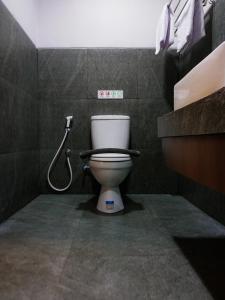 a bathroom with a toilet and a shower at Singgah Ijen in Biau