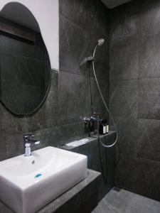 a bathroom with a sink and a shower with a mirror at Singgah Ijen in Biau +3 photos