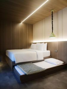 a bedroom with two beds and a light fixture at Singgah Ijen in Biau