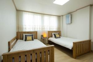 a bedroom with two beds and a window at 옥상달빛 게스트하우스 in Seoul +5 photos