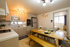 a kitchen and living room with a table in it at 옥상달빛 게스트하우스 in Seoul