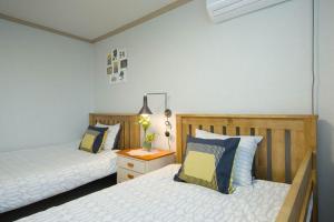 a bedroom with two beds and a table with a night stand at 옥상달빛 게스트하우스 in Seoul