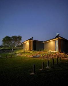 a house in a field at night with lights at Alquimia House tu refugio en Santa Ana in Corrientes