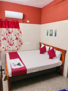 a small bedroom with a bed with red walls at Hotel Jyothi Kumar Royal ac rooms in Srikalahasti