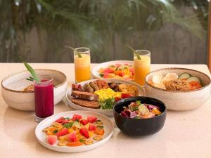 a table with three bowls of food and drinks at NORI Boutique Villas Uluwatu - Breakfast Available in Uluwatu