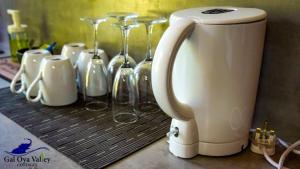 a mixer sitting on top of a counter with wine glasses at Gal Oya Valley Cottages in Ampara