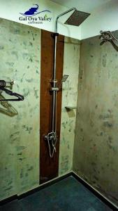 a shower in a room with a wooden door at Gal Oya Valley Cottages in Ampara