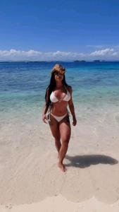 a woman in a bikini walking on the beach at Cabañas con baño Privado in Soledad Miriá Ubigantupo