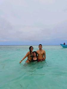 a group of three people standing in the ocean at Cabañas con baño Privado in Soledad Miriá Ubigantupo