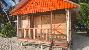 a small shack on the beach with an orange roof at Cabañas con baño Privado in Soledad Miriá Ubigantupo
