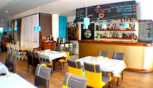 een restaurant met tafels en stoelen en een bar bij Murex Plaza Hotel & Suites in Monrovia