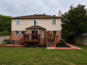a large house with a large deck in the yard at Newly Renovated 2BR Walkout Suite in the Heart of Kanata Ottawa in Ottawa