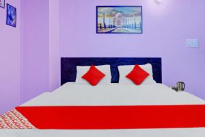 a bedroom with a large bed with red pillows at Super Hotel O New View in Bankipur