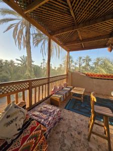 a porch with a view of the ocean and palm trees at Siwa Spot - Authentic Siwan Room with Private Patio in Siwa