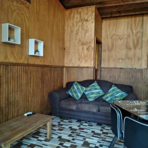 a living room with a couch and a table at cabañas roccajoma in Salto del Laja