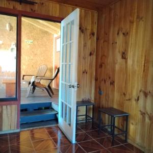 a room with a door and a chair on a porch at cabañas roccajoma in Salto del Laja