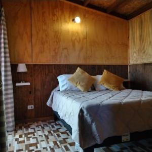 a bedroom with a bed with a wooden wall at cabañas roccajoma in Salto del Laja +45 photos