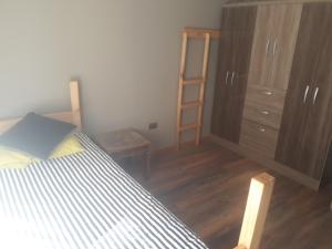a bedroom with a bed and a dresser and a ladder at la casa del cerro in Casas de Batuco +3 photos