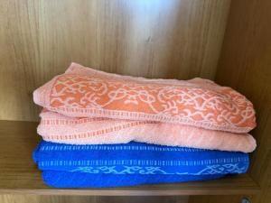 a stack of pink and blue towels sitting on a shelf at Estrela-do-mar in Serra +15 photos