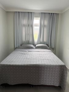 a bed in a room with a window at Estrela-do-mar in Serra