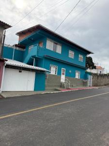 a blue house on the side of a street at Estrela-do-mar in Serra