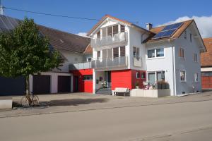 a white and red house on a street at Ferienwohnung Hummel in Gammertingen