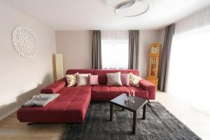 a red couch in a living room with a table at Ferienwohnung Hummel in Gammertingen