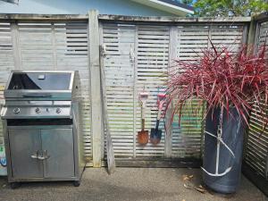 a grill and plants in a container next to a fence at Diamond Retreat in Tairua