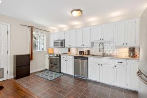 a white kitchen with white cabinets and appliances at Surrey Two Bedroom Suite with Pool Access in Surrey