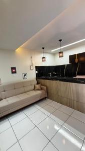 a living room with a couch and a counter at Flat Ubuntu in Viçosa do Ceará
