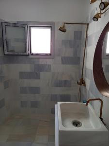 a bathroom with a white sink and a window at I have a big dream in Agia Pelagia