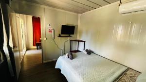 a bedroom with a bed and a tv on the wall at Apartamentos Equipados DMR #3 in Uvita