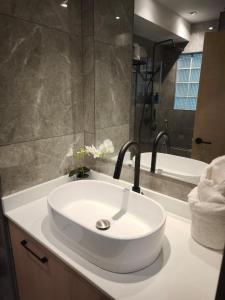a bathroom with a white sink and a bath tub at Stylish Studio Condo on the Beach in Ban Pak Khlong Phe +15 photos