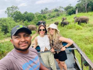 a man and two women riding on a boat with elephants at Shaa Home Stay Sigiriya in Sigiriya