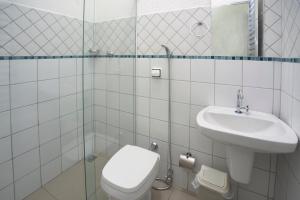 a bathroom with a toilet and a sink at Hotel São João in Piracicaba