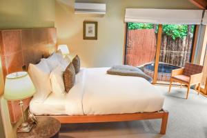 a bedroom with a bed and a chair and a window at River Birches in Turangi