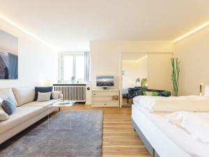 a white living room with a couch and a tv at Kliffsand-68 in Kampen