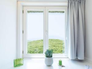 a window with a potted plant sitting on a window sill at Kliffsand-68 in Kampen