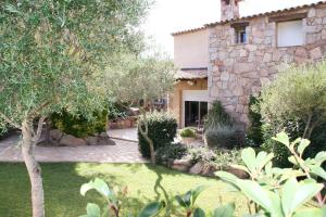 a stone house with a garden in front of it at Concadoro in Porto-Vecchio