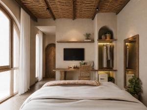 a bedroom with a bed and a desk with a television at Soho Boutique in Quảng Ngãi