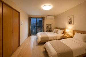 a hotel room with two beds and a window at SaiKa 隠れ家 in Saikamachi