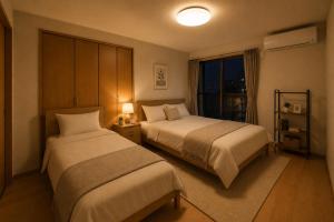 a hotel room with two beds and a window at SaiKa 隠れ家 in Saikamachi +12 photos